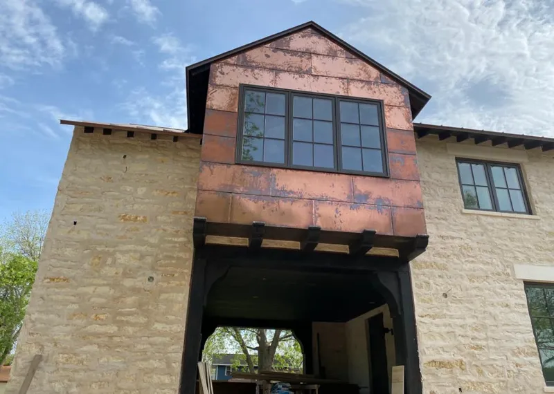 Copper metal panel facade on a stone building for Roof Repair in Mequon