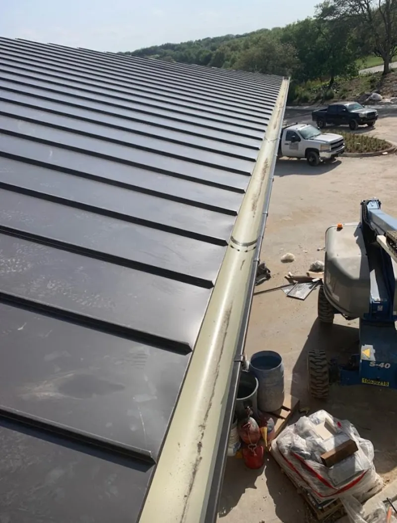 Standing seam panel and gutter detail on a metal roofing jobsite in Mequon